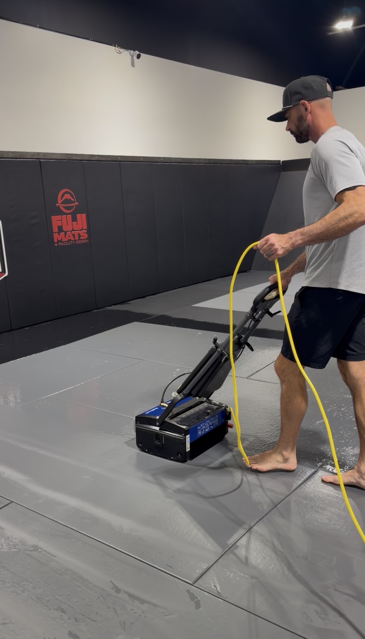 Mat Guard Services technician cleaning gym mats with professional equipment
